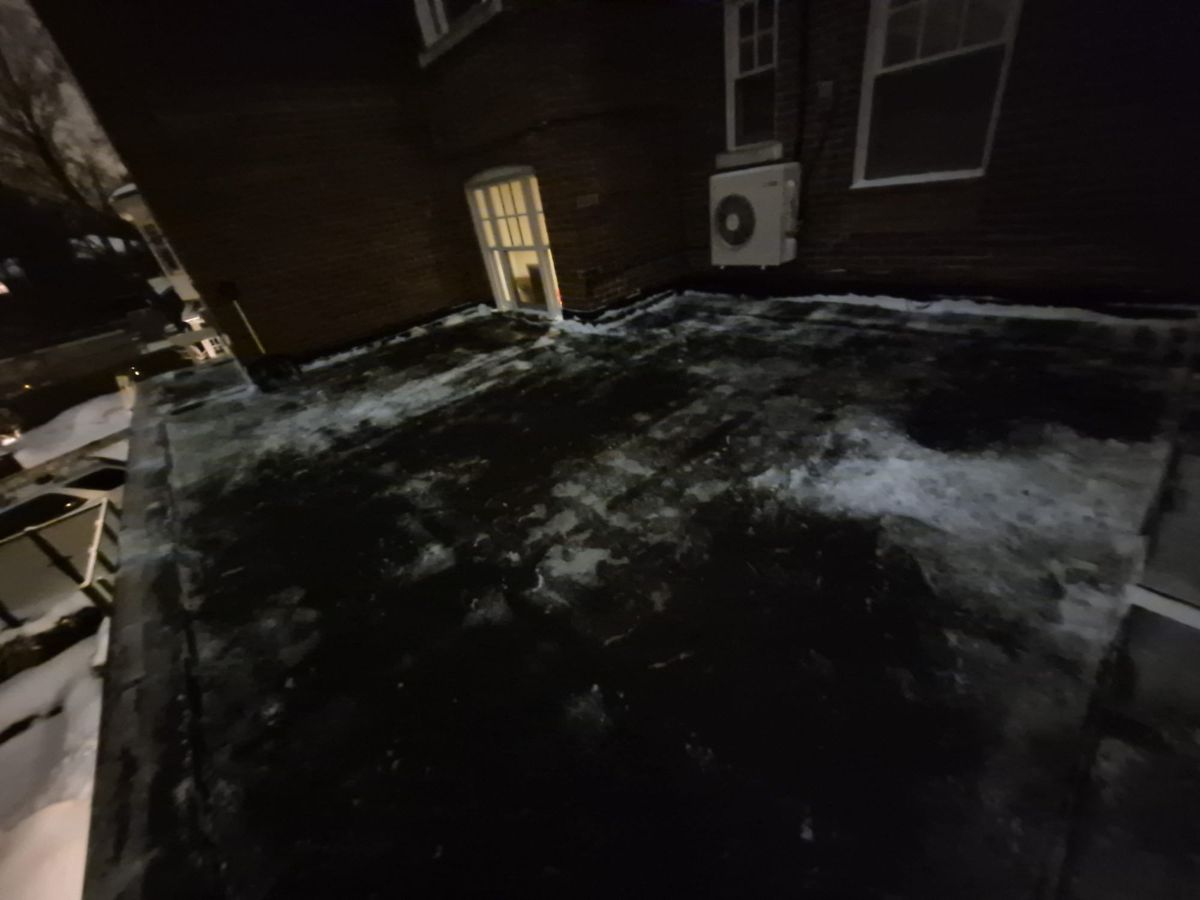 Roof terrace outside a back door cleared after an evening snowfall